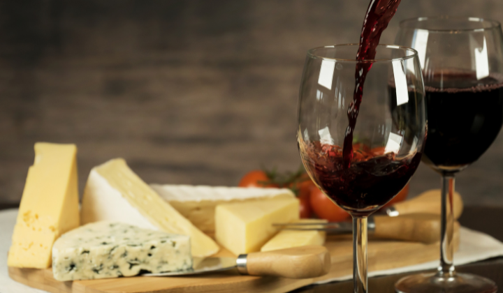 Qu’est-ce que l’histamine? Planche de fromages avec variation de fromages et deux verres à vin rouge